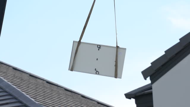 Crane operation is lifting a solar cell panel. 4K Footage.