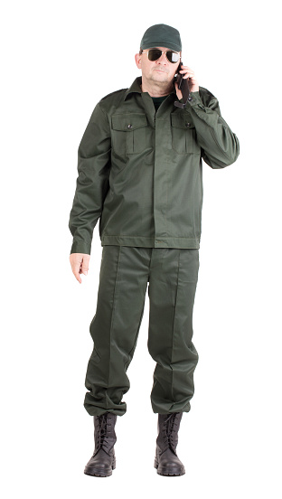 A man in a military uniform talks on the phone. Isolated on a white background. Close-up.