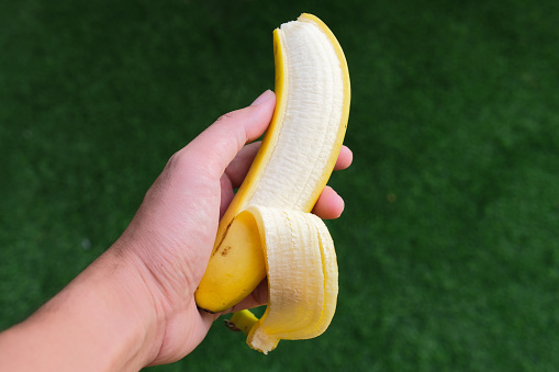 A hand showing peeled banana fruit