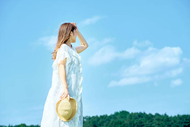 A young woman showing a relaxed expression under the clear sky