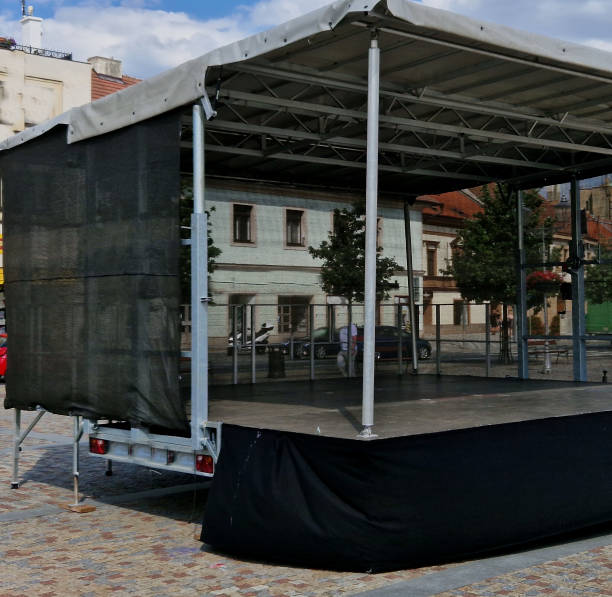 music stage built of aluminum beams. the folding design with a black tarpaulin will enable musical, theatrical, cultural performances in any weather. the straps stabilize in the wind, town square - ropes backstage theater imagens e fotografias de stock