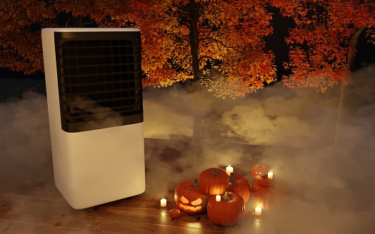 portable air conditioner on a background with autumn trees with candles and pumpkins in the fog