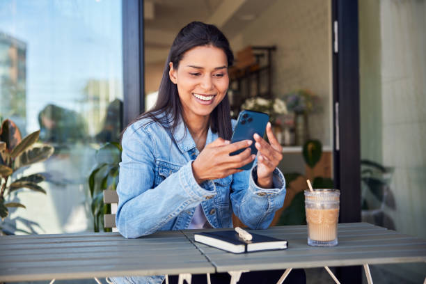istock Happy young woman using mobile phone sitting at outdoors cafe 1622279207