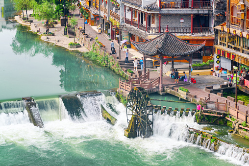 Fenghuang, China - September 23, 2017: Awesome aerial view of water wheel and scenic waterfall on the Tuojiang River (Tuo Jiang River) in Phoenix Ancient Town (Fenghuang County).
