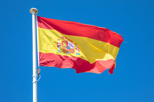 spain flag spanish country flag red yellow on top of the mast in the wind and blue sky