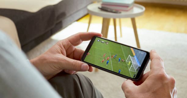 Mann, der Fußball auf dem Smartphone beobachtet – Foto