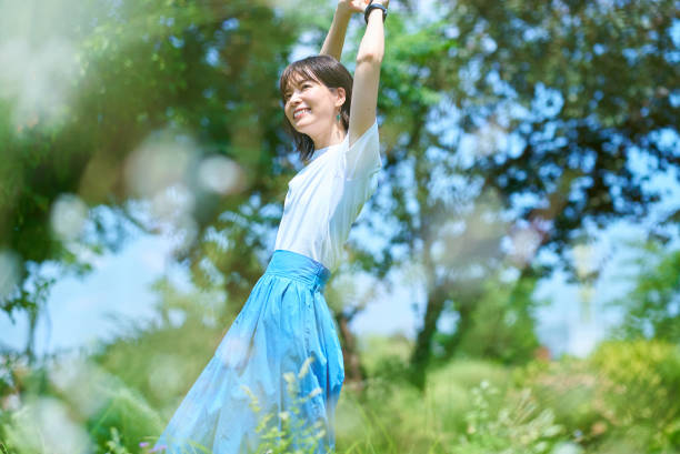 Woman relaxing in green space on fine day