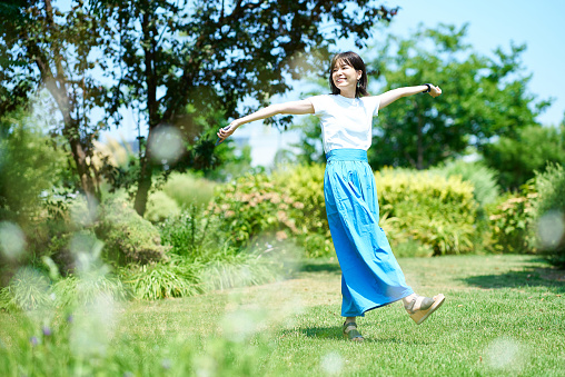 Woman relaxing in green space on fine day