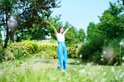 Woman relaxing in green space on fine day