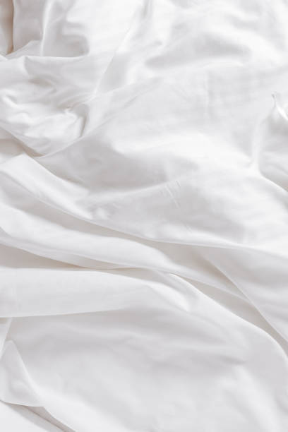istock White fabric texture background, wavy cloth. Crease bedclothes fragment as background, Crumpled sheet of bed. White bed linen as minimal backdrop. Top view aesthetic surface, screensaver 1622330182