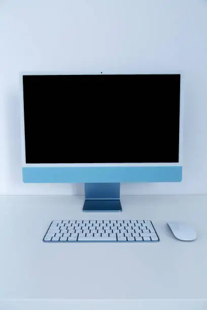 Photo of Desktop computer with wireless keyboard and mouse. New model multicolored Apple iMac