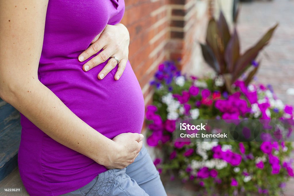 Mulher grávida segurando barriguinha - Foto de stock de Abdome royalty-free