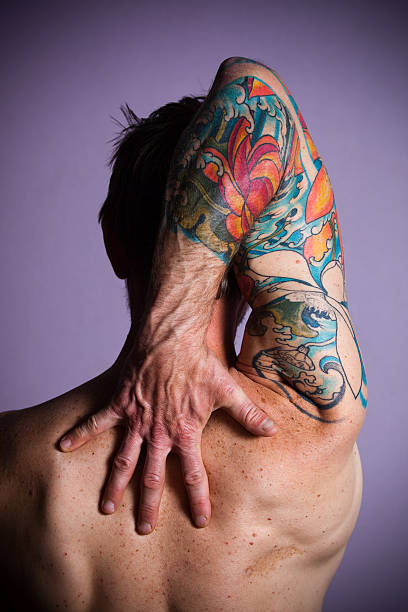 tattoo a man's arm and hand with tattoo sleeve portrait. vertical rearview. arm tattoo ideas for men pictures stock pictures, royalty-free photos & images