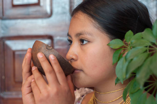 giovane indigeno di una tribù otavalo che beve un liquido sacro da una ciotola di guscio di cocco - indigenous culture australia aborigine australian culture foto e immagini stock