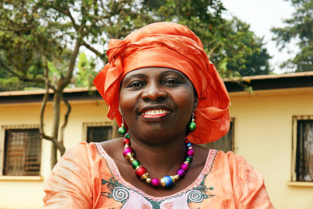 smiling african woman in orange scarf - boubou stockfoto's en -beelden