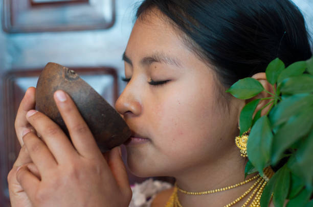 jeune indigène d’une tribu otavalo buvant un liquide sacré dans un bol en coquille de noix de coco - aborigine indigenous culture australian culture australia photos et images de collection