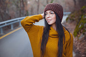 positive cheerful woman enjoy autumn in park or woods wear yellow pullover and hat.