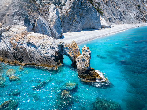 Aerial closeup view of the natural stone arch and turquoise sea at Lalaria beach, Skiathos island, Sporades, Greece