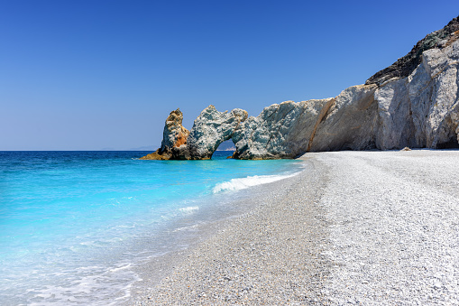 The beautiful beach of Lalaria, Skiathos island, Sporades, Greece, with light gray pebble stones and turquoise, shining sea