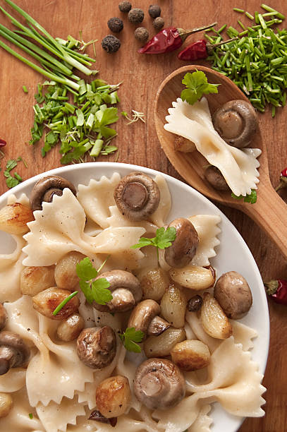 Pasta with grilled mushrooms and onions Pasta with grilled mushrooms and onions with spice, fresh parsley and onions. Ukranian food cooked selective focus vertical pasta stock pictures, royalty-free photos & images