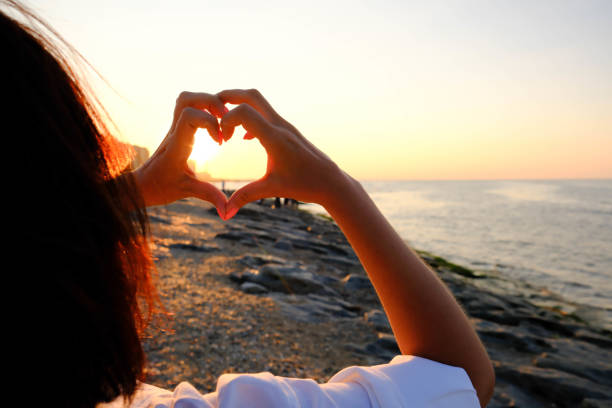 istock woman hands are making love on sea background. 1622388975