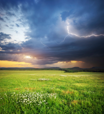 Mountain landscape. Lightning and green meadow.