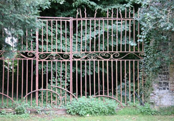 An aged and dilapidated gateway driveway. \nA green and historical background.