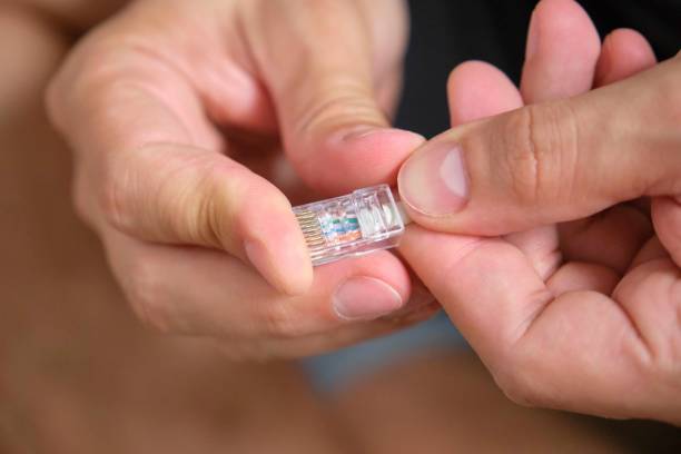 istock Man hands attaching net cable to RJ45 connector. 1622394710