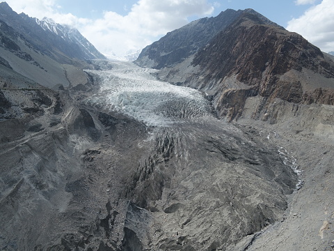 The photograph captures Passu Glacier during the month of May 2022. 
Passu Glacier, a magnificent natural wonder nestled within the awe-inspiring Karakoram Range, showcases its timeless beauty. This glacier, a true spectacle of nature's grandeur, captivates with its icy expanse and intricate formations. Flowing majestically through the rugged terrain, Passu Glacier stands as a testament to the Earth's ancient history and the relentless forces that have shaped our planet. Its icy serenity and colossal presence evoke a sense of both wonder and humility, inviting all who gaze upon it to contemplate the remarkable power and beauty of the natural world.