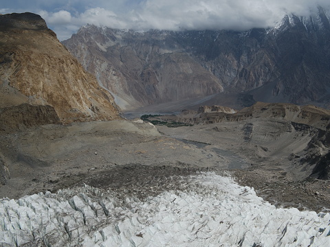 The photograph captures Passu Glacier during the month of May 2022. 
Passu Glacier, a magnificent natural wonder nestled within the awe-inspiring Karakoram Range, showcases its timeless beauty. This glacier, a true spectacle of nature's grandeur, captivates with its icy expanse and intricate formations. Flowing majestically through the rugged terrain, Passu Glacier stands as a testament to the Earth's ancient history and the relentless forces that have shaped our planet. Its icy serenity and colossal presence evoke a sense of both wonder and humility, inviting all who gaze upon it to contemplate the remarkable power and beauty of the natural world.