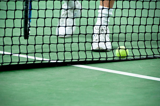Feet approaching a ball on the tennis court stock photo