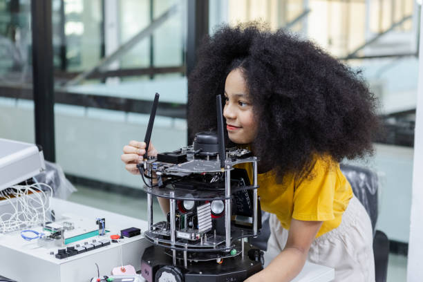 istock children girl with afro hairstyle education electronic on table at class room. learning innovation electronic for future AI. electric system skill training. STEM education concept. 1622440205
