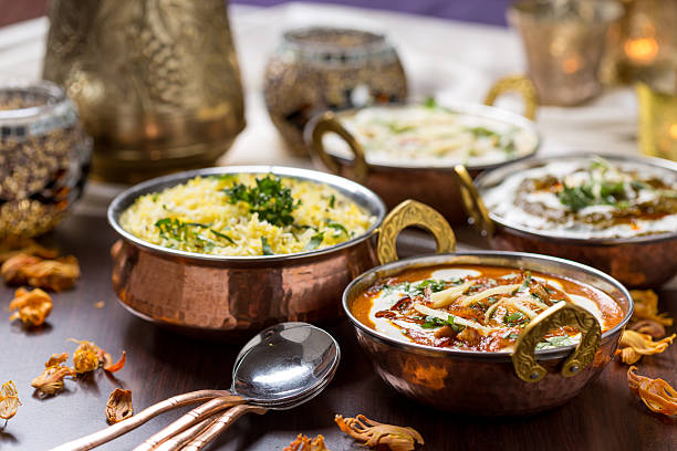 Table filled with freshly made Indian food indian food in brass bowl flatbread photos stock pictures, royalty-free photos & images