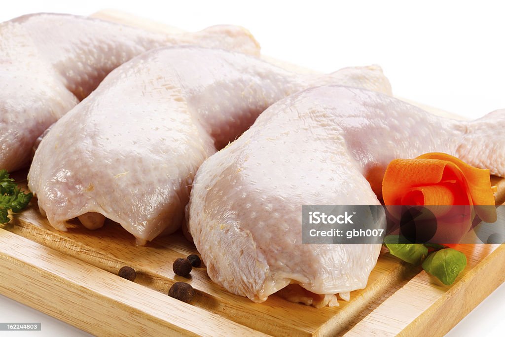 Cosce di pollo crudo sul Tagliere - Foto stock royalty-free di Carne