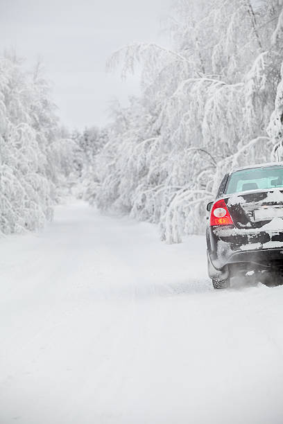 冬の道路には、ブラックカー立つ路傍 - rear view winter blizzard nordic countries ストックフォトと画像