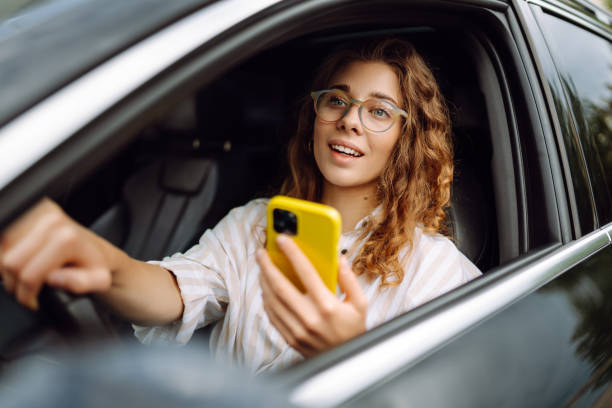 istock Stylish woman driving a car and using a mobile phone. 1622465259