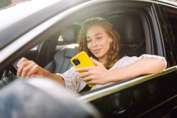 istock Stylish woman driving a car and using a mobile phone. 1622465632