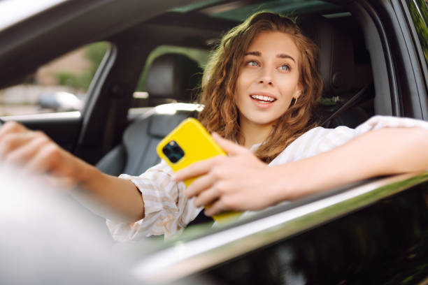 istock Stylish woman driving a car and using a mobile phone. 1622465646