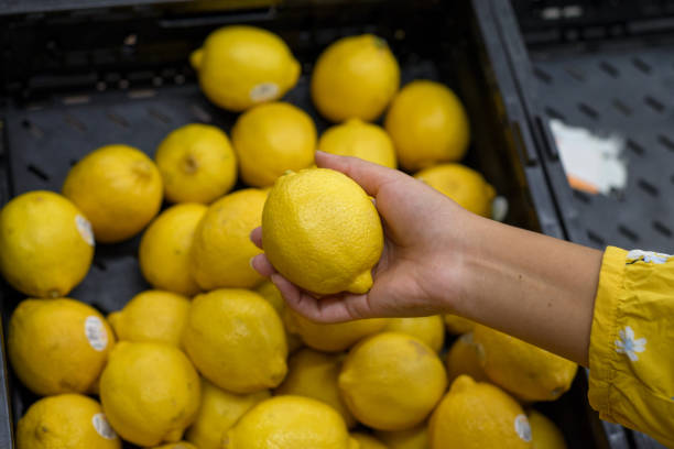 istock Person holding a lemon in a supermarket. 1622472265