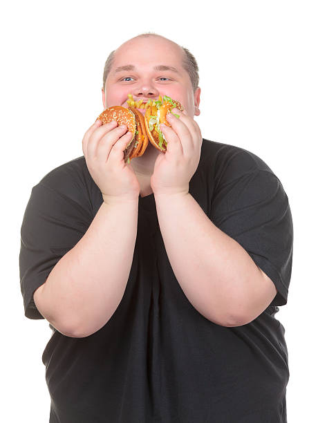 istock Fat Man Looks Lustfully at a Burger 162247417