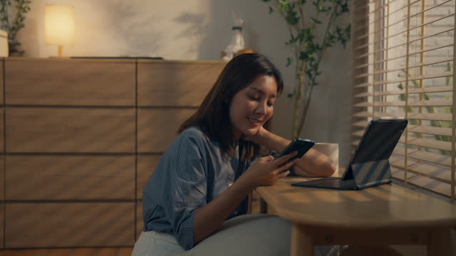 Asian woman using smartphone at home