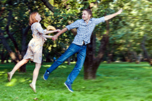 istock Happy young couple flying in the summer park 162248220