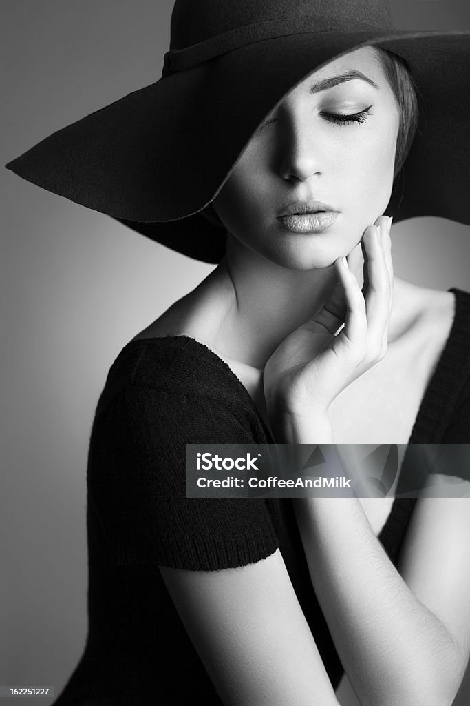 Jeune Belle femme portant un chapeau sur fond sombre - Photo de Femmes libre de droits