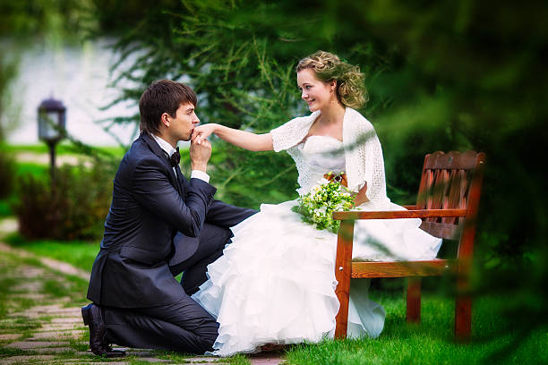 Groom kneeling before the bride stock photo