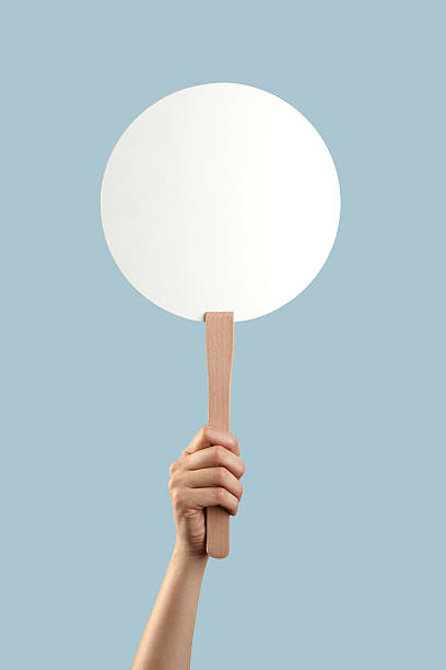 White auction placard with a hand holding it up