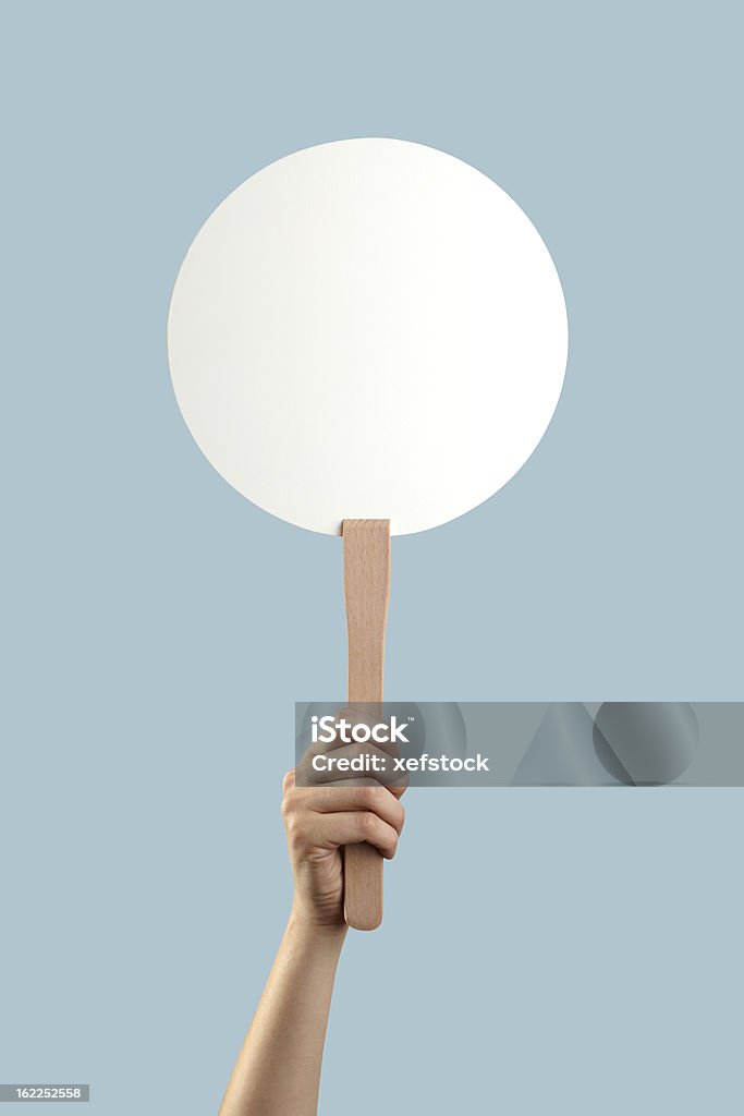 White auction placard with a hand holding it up Someone is holding a blank placard. Sign Stock Photo