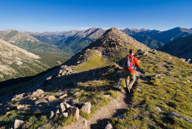 Man recreating and exploring along mountain ridge high in mountains.  LaPlata Peak, Sawatch Range, Colorado.  Captured as a 14-bit Raw file. Edited in 16-bit ProPhoto RGB color space.