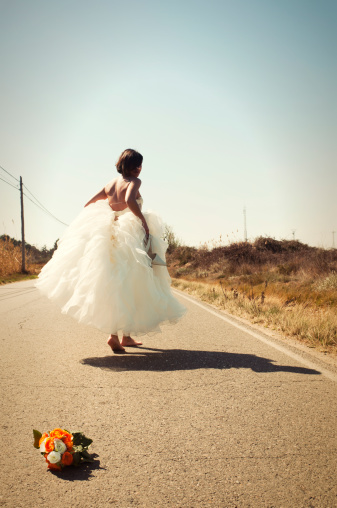 escape at the moment, bride running away with  shoes in her hand