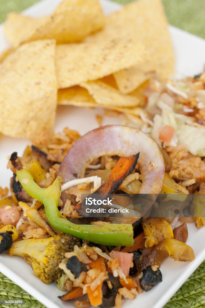 Mexican vegetable stir fri with corn chips Mexican cuisine: Square plate of stir fried vegetables with corn chips and guacamole Bean Stock Photo