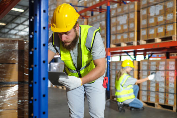 istock Male worker holding tablet with female colleague using barcode scanner to count inventory in warehouse. 1622534734